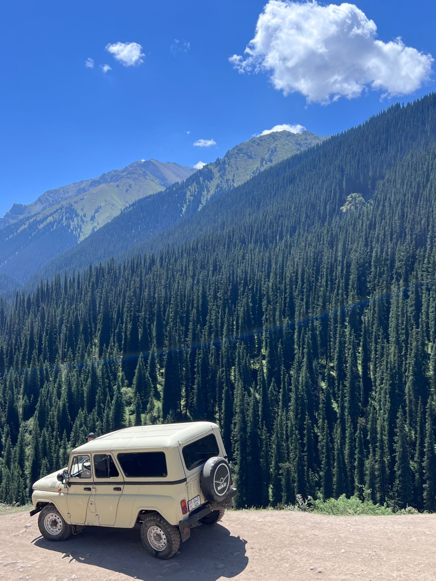 4x4 UAZ sur la route de montagne vers Altyn-Arashan, forêt de sapins